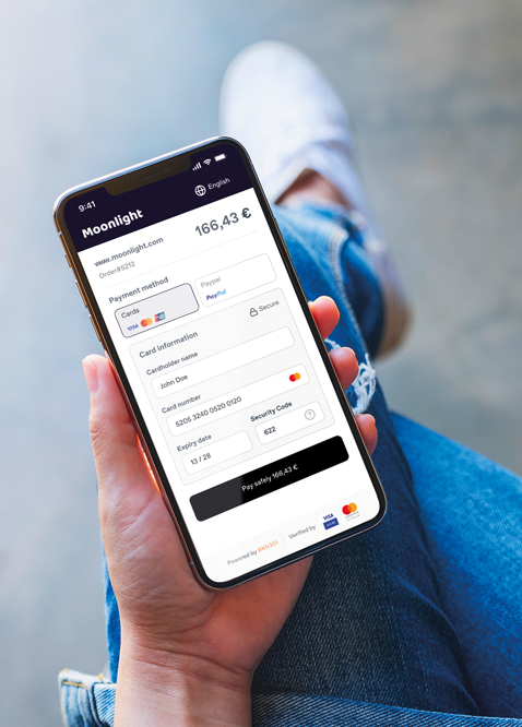 foto ripresa dall'alto di una persona che tiene in mano uno smartphone e dove si vede l'interfaccia di una app per i pagamenti digitali.