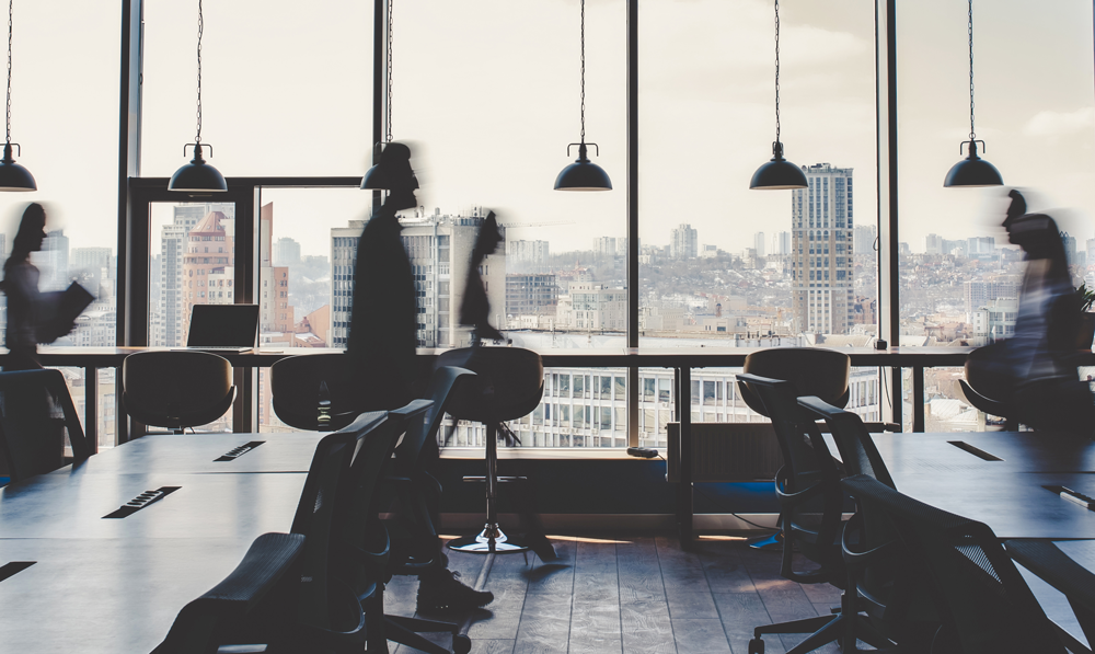 immagine di un ufficio con persone sfocate che si muovono da una parte all'altra.