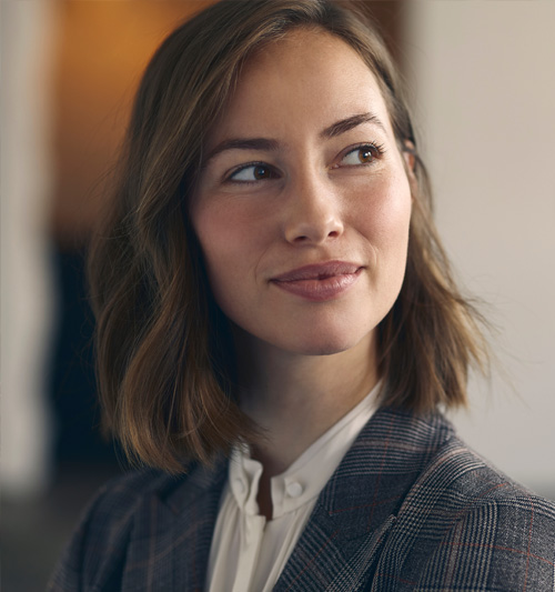 Immagine decorativa. Ritratto di una ragazza bianca con capelli castano chiaro tagliati con un caschetto lungo e mosso. la ragazza guarda verso destra con sguardo curioso.